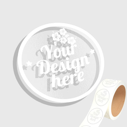 Roll of white stickers with 'Your Design Here' text on a light gray background
