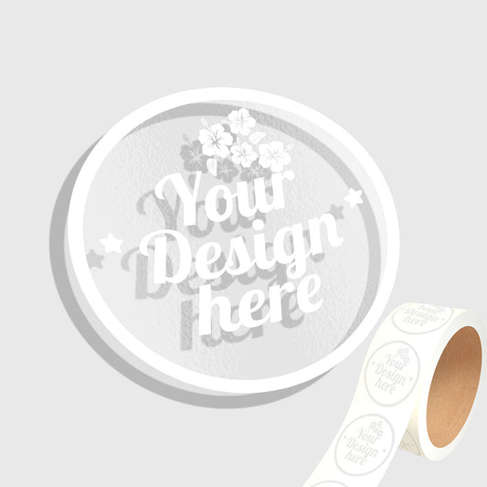 Roll of white stickers with 'Your Design Here' text on a light gray background